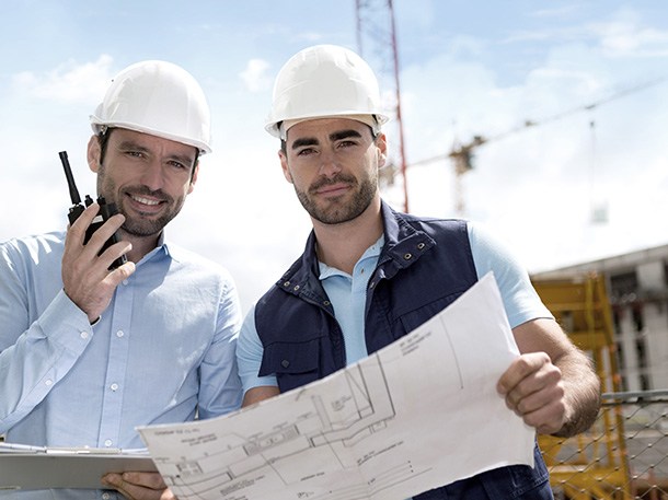 two electricians holding blueprints